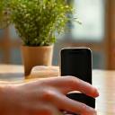 A person carefully placing a smartphone face down on a wooden table, suggesting a digital detox and boundary setting
